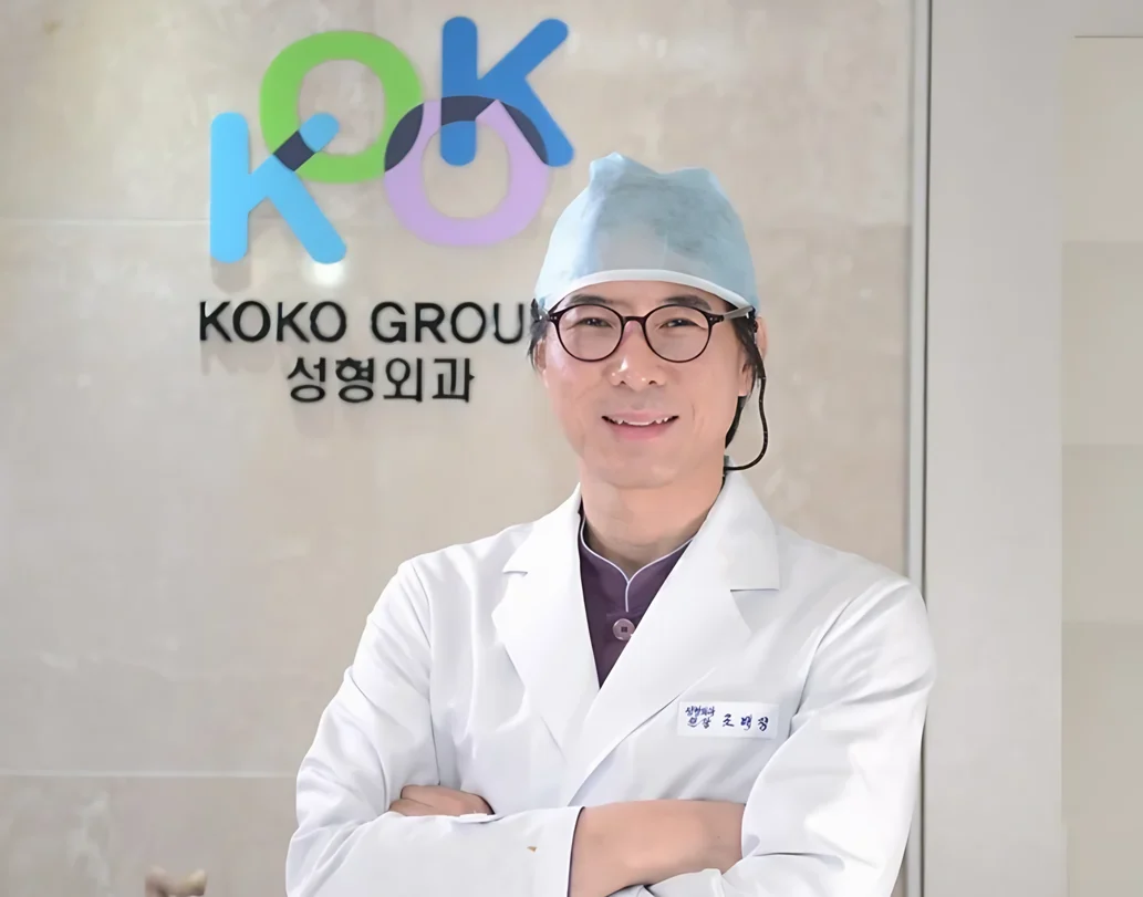 KOKO美容外科のロゴの前に立つ、代表院長ジョ・ベジョン