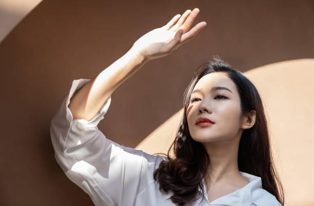 韓国ソウルでの鼻整形はKOKO美容外科での手術をお勧めするブログ内の参考画像。女性が太陽の光を手で隠している様子