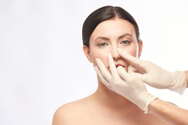 KOKO美容外科のブログ内のイメージ画像。医療用手袋をした手が女性の鼻を触っている様子